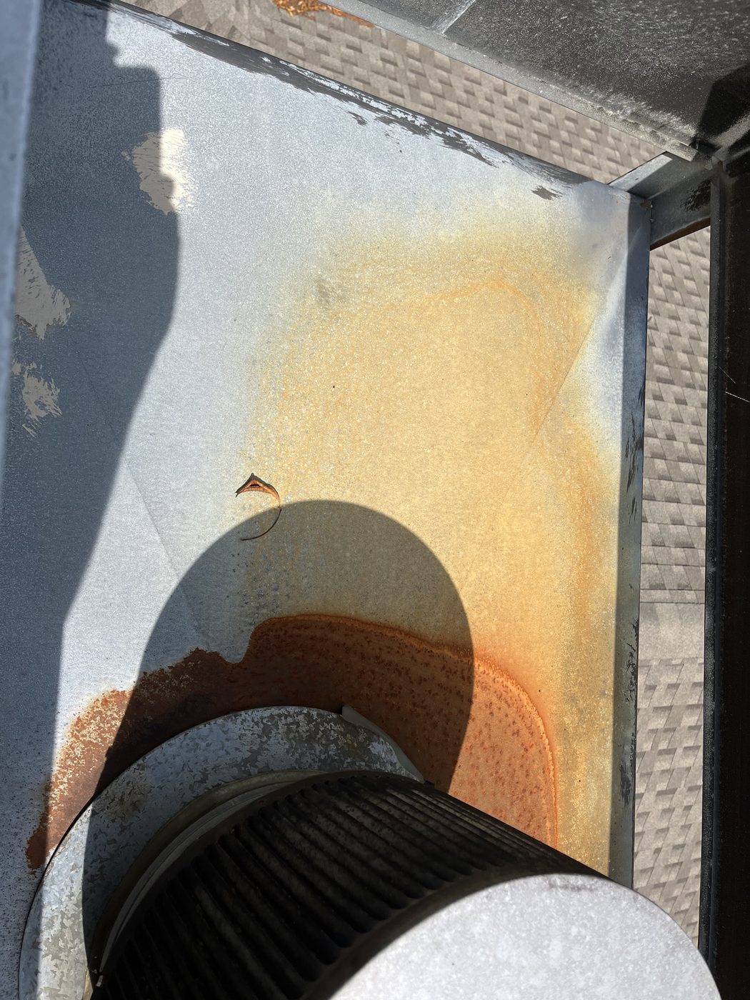 Rust where water pools on chimney cap rain pan